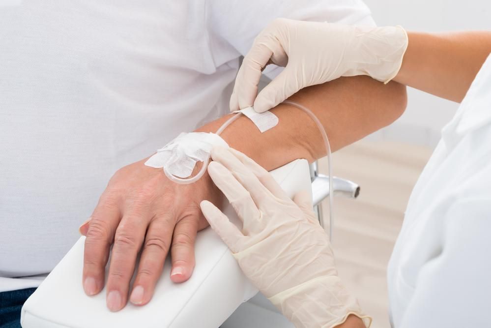 Clinician gently placing an IV line in a patient's arm